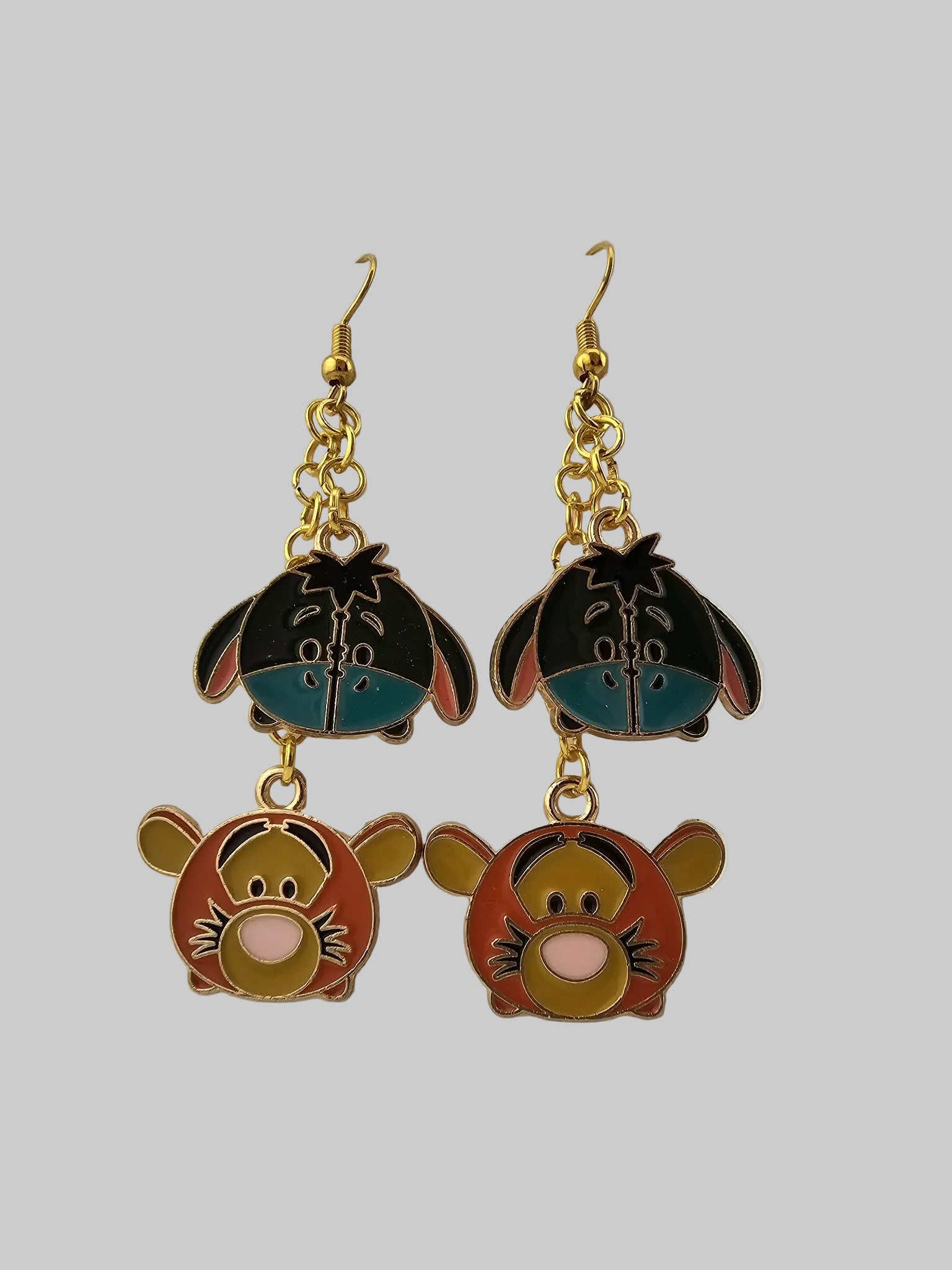 Cartoon character earrings on a white display card with a gray background